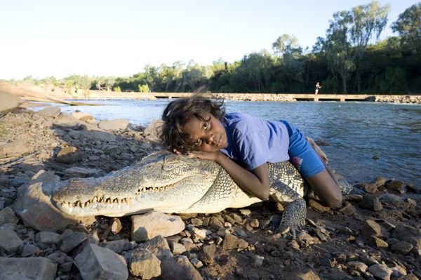 Shakira Miler sits on a crocodile